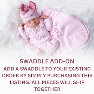 May include: A pink swaddle blanket with the name "Atalia Rose" embroidered on it. The swaddle is shown with a pink baby outfit and a pink bow headband.