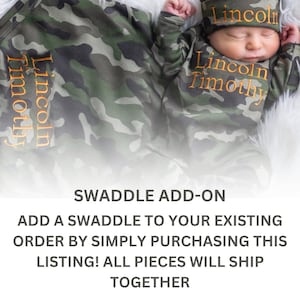 May include: A camouflage swaddle blanket with the names "Lincoln Timothy" embroidered in orange thread. The swaddle is shown with a matching baby outfit and hat.