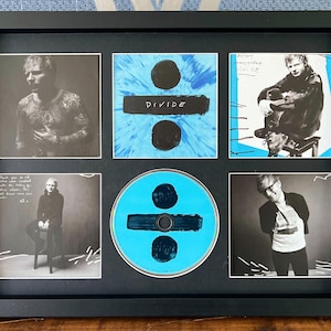 Può includere: Un espositore incorniciato nero con un CD e cinque immagini. Il CD e un'immagine hanno uno sfondo blu con un segno uguale nero. Le altre immagini sono ritratti in bianco e nero. La parola "DIVIDE" è su un'immagine.