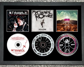 Peut inclure: Cadre avec trois pochettes d'album et trois CD du groupe My Chemical Romance. Les pochettes incluent "Three Cheers for Sweet Revenge" et "The Black Parade". Les CD présentent également des illustrations d'album.