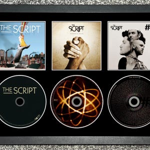 Può includere: Una cornice nera contenente tre copertine di album dei The Script e tre CD corrispondenti. La fila superiore mostra l'album omonimo, Science & Faith e #3. La fila inferiore mostra i CD abbinati, incluso uno con una grafica di un atomo luminoso.