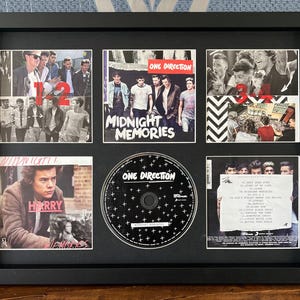 Op de afbeelding: Zwart omlijste collage met afbeeldingen van de band One Direction. Bevat albumhoezen voor "Midnight Memories" en een cd. De collage toont ook de bandleden en de tekst "12".