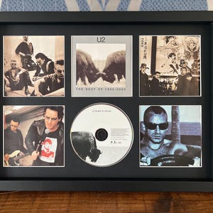 Könnte beinhalten: Ein schwarzer Rahmen mit Albumcovern und einer CD. Der Rahmen enthält sechs Bilder, darunter eine CD in der Mitte. Die Albumcover zeigen Bandmitglieder und Albumcover. Die CD hat ein Büffelbild.