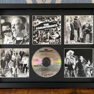 May include: A black framed display featuring a CD and five black and white photographs. The CD is labelled "The Commitments". The photographs show band members and the film soundtrack cover.
