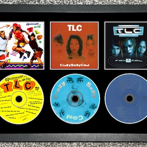 Op de afbeelding: Ingelijste kunst met drie TLC-albumhoezen en drie cd's. De albumhoezen zijn "Ooooooohhh... On the TLC Tip", "CrazySexyCool" en "FanMail". De cd's zijn geel, blauw en blauw, elk met albumkunst.