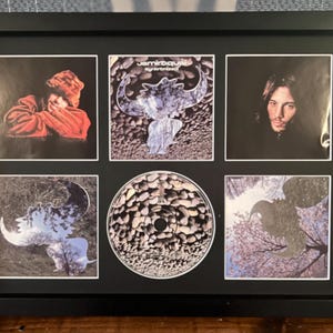 May include: Framed Jamiroquai album art and CD. The black frame contains six images, including album covers and a CD. The album art features images of the band members and abstract designs. The CD is in the center.