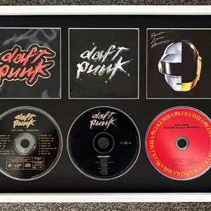 Może przedstawiać: Biała ramka z trzema okładkami albumów Daft Punk i trzema odpowiadającymi im płytami kompaktowymi. Górny rząd przedstawia okładki Homework, Discovery i Random Access Memories. Dolny rząd prezentuje trzy pasujące do nich płyty muzyczne.