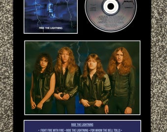 May include: A framed display featuring the Metallica album "Ride the Lightning." It includes the album cover art with a blue lightning design, a CD, a band photo, and a tracklist. The album was released in 1984.