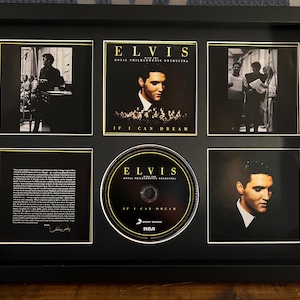 Może przedstawiać: Czarna, oprawiona pamiątka po Elvisie Presleyu. Rama zawiera płytę CD, okładki albumów i zdjęcia. Na okładce albumu widnieje napis "Elvis with the Royal Philharmonic Orchestra If I Can Dream".