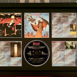 May include: Framed Meat Loaf album art and CD. The artwork features images from the album, including a woman in a red room, a winged creature, and song lyrics. The CD is in the center.