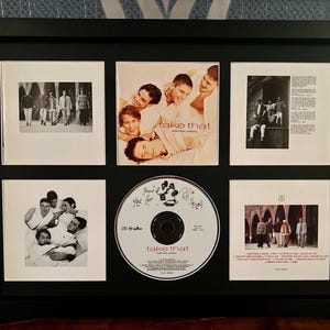以下が含まれることがあります： Take ThatのCDと白黒写真が入った黒いフレーム。CDは中央にあり、6つの画像に囲まれています。CDにはバンド名とアルバムタイトルが記載されています。