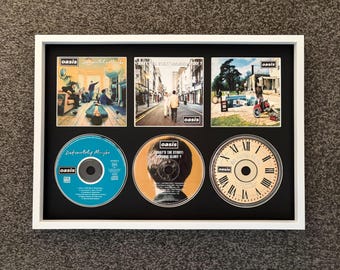 Oasis | Zdecydowanie może | Co jest grane (Morning Glory?) | Be Here Now | Potrójny stojak ścienny na płyty CD w stylu retro | Rama nie jest dołączona |