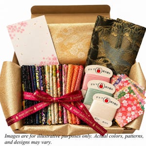 May include: A gift box containing a collection of folded fabric strips in various colors and patterns, tied with a red ribbon printed with Merry Christmas. Includes three spools of thread with Japanese text, a card with pink cherry blossoms, and gold fabric.