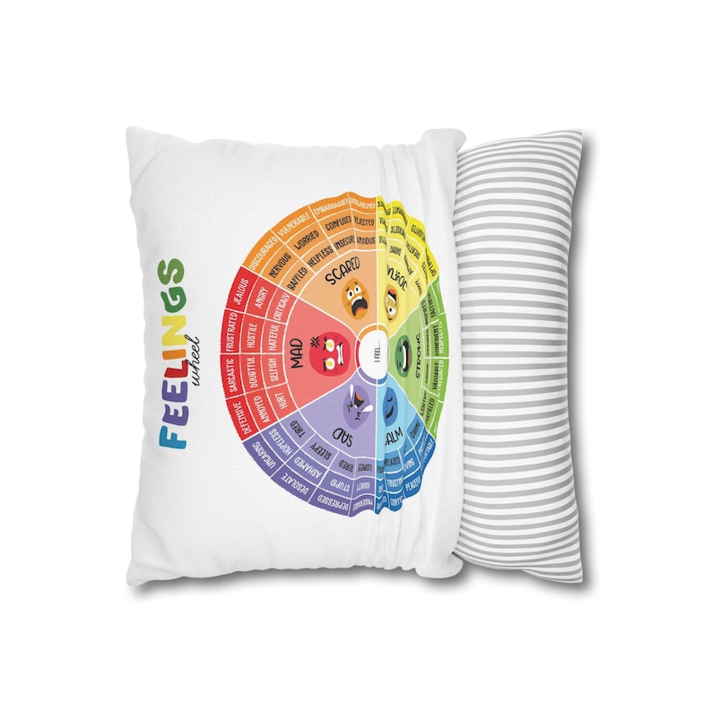 Two Feelings Wheel pillow covers with colorful emotion charts displayed side by side on a gray sofa, plaid blanket nearby, SEL classroom and calm down corner decor for kids.