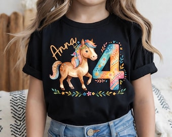 Puede incluir: Camiseta negra con un caballo marrón con melena y cola coloridas, el nombre "Anna" y el número "4". El diseño incluye elementos florales y estrellas, ideal para una celebración de cuarto cumpleaños.