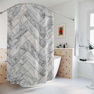 May include: A white and gray marble-patterned shower curtain hangs from a curved, silver-colored shower rod. The curtain's design features a repeating, angled pattern. The bathroom has white walls, a white tub, and a small table with a vase.