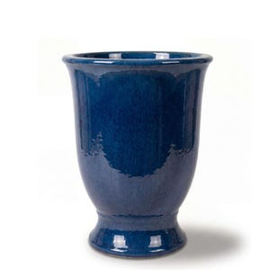 Peut inclure: Un vase en céramique bleu profond avec une finition brillante et réfléchissante. Le récipient présente un bord large et évasé qui se rétrécit vers un col étroit, s'élargissant en un corps arrondi, reposant sur une base piédestal circulaire.