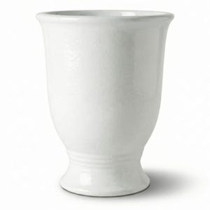 Könnte beinhalten: Eine weiße Keramikvase mit glatter, glänzender Oberfläche. Das Gefäß hat einen breiten, ausgestellten Rand, der sich zu einem schmalen Hals verjüngt, in einen abgerundeten Körper übergeht und auf einem runden Sockel mit feinen Rillen endet.
