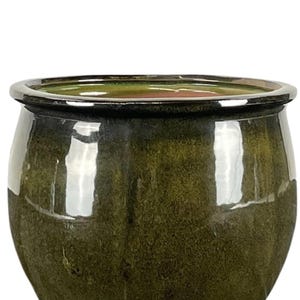 Könnte beinhalten: Ein glänzender, olivgrüner Keramik-Pflanztopf mit runder Form und silbernem Rand. Der Pflanztopf hat eine glatte, reflektierende Oberfläche, und das Innere ist in einem helleren Grünton gehalten. Dieser dekorative Topf ist für den Innen- und Außenbereich geeignet.