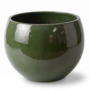 Peut inclure: Un pot de fleurs sphérique doté d'une finition émaillée vert forêt profond et brillant. Le pot présente une large ouverture circulaire sur le dessus et un corps lisse et arrondi qui se rétrécit vers la base, reflétant la lumière.