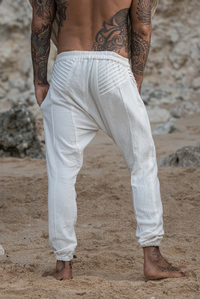 K&ouml;nnte beinhalten: Wei&szlig;e Baumwollhose mit einem einzigartigen Falten-Design am R&uuml;cken. Die Hose hat eine lockere Passform und einen umgeschlagenen Saum.