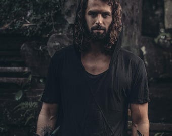 May include: A black hooded t-shirt with short sleeves and a deep scoop neckline. The garment features a dark, solid color throughout and is constructed with a lightweight fabric that drapes over the shoulders and chest, creating a relaxed fit.