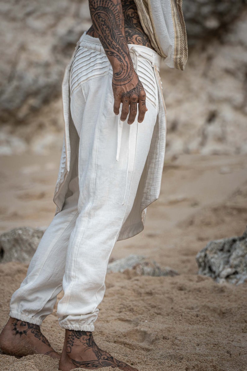 K&ouml;nnte beinhalten: Wei&szlig;e Leinenhose mit Kordelzugbund und langem, flie&szlig;endem Fall hinten. Die Hose hat eine lockere Passform und ist perfekt f&uuml;r einen l&auml;ssigen, bohemian Look.