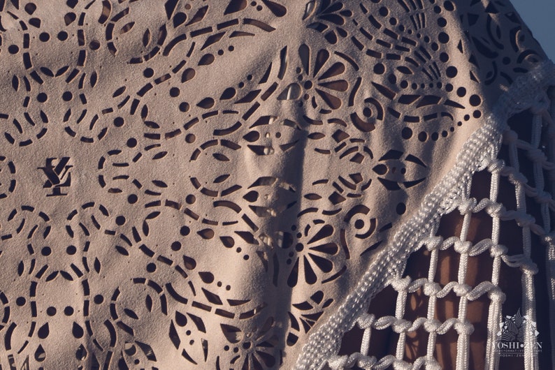 May include: A white crocheted top with a delicate floral pattern and a fringe trim. The top features a cut-out design and a logo on the front.