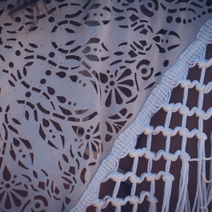 May include: White crochet shawl with a delicate floral pattern and fringe trim. The shawl is made of a lightweight, breathable fabric and is perfect for layering.