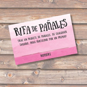 May include: Pink and white watercolor-style card with the text "RIFA DE PAÑALES" in black. The text below reads "TRAE UN PAQUETE DE PAÑALES, DE CUALQUIER TAMAÑO, PARA PARTICIPAR POR UN PREMIO!" and "NOMBRE" at the bottom.