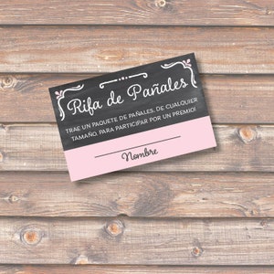 May include: A pink and black raffle ticket with the text "Rifa de Pañales" and the instructions "TRAE UN PAQUETE DE PAÑALES, DE CUALQUIER TAMAÑO, PARA PARTICIPAR POR UN PREMIO!" and a line for a name.