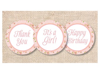 Könnte beinhalten: Drei runde Aufkleber in Rosa und Weiß mit Blumenmustern. Die Aufkleber haben den Text "Danke", "Es ist ein Mädchen!" und "Alles Gute zum Geburtstag" aufgedruckt.