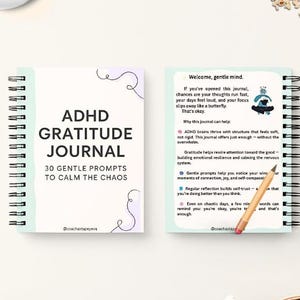 Puede incluir: Un diario azul verdoso con una encuadernación en espiral blanca y el texto "ADHD Gratitude Journal" y "30 Gentle Prompts to Calm the Chaos". El diario tiene un fondo azul claro con un garabato blanco de una mariposa en la portada.