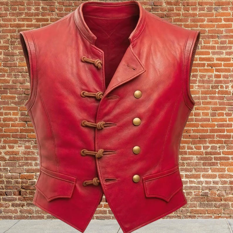 K&ouml;nnte beinhalten: Eine rote Lederweste mit Stehkragen und messingfarbenen Kn&ouml;pfen. Die Weste hat zwei Vordertaschen und dekorative Knebelverschl&uuml;sse. Das &auml;rmellose Design und die taillierte Passform deuten auf eine Vintage- oder Steampunk-&Auml;sthetik hin.