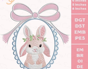 May include: Embroidered design of a pink bunny wearing a floral crown, framed by a light blue oval and a pink bow. The design is labeled with sizes: 4, 5, and 6 inches. Also includes embroidery file formats.