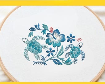 May include: An embroidery design featuring two sea turtles and a hibiscus flower in shades of teal and blue. The design is on white fabric, stretched within a wooden hoop. The text reads "Embroidery Design 3 size: 3, 4, 5 inches."