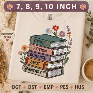 May include: A cream-colored t-shirt featuring an embroidered stack of five books with the words CRIME, FICTION, ROMANCE, SMUT, and FANTASY printed on the spines. The design includes colorful floral stems and leaves surrounding the book stack.