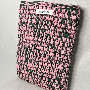 Könnte beinhalten: Handgefertigte, rechteckige Häkeltasche in Rosa und Dunkelgrün. Die Tasche hat ein gewebtes Muster und einen rosafarbenen Rand. Das Etikett "marloni." ist sichtbar. Diese stilvolle Tasche ist ideal für den Transport von Essentials. Maße: ca. 25 cm x 20 cm.