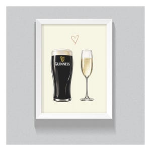 May include: A framed print featuring a pint of Guinness and a champagne flute. The Guinness glass is black with the brand logo, and the champagne glass is filled with a bubbly, light-colored liquid. A small red heart is drawn above the glasses.