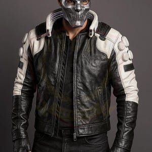 May include: Black and white leather jacket with a silver mask. The jacket has a black body with white shoulder and sleeve accents. The jacket features a zip closure and decorative circular elements on the shoulders.