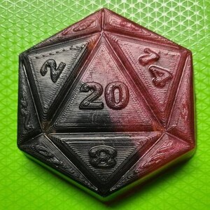 K&ouml;nnte beinhalten: Ein schwarzer und roter 20-seitiger W&uuml;rfel mit den Zahlen 2, 8, 14 und 20 sichtbar. Der W&uuml;rfel ist aus einem strukturierten Kunststoffmaterial.