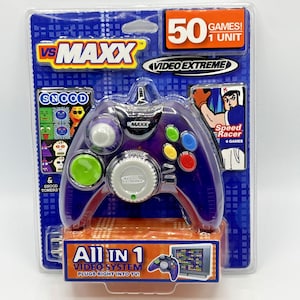 Può includere: Un controller per videogiochi VS Maxx viola con pulsanti colorati, confezionato in un blister blu e arancione. La confezione include il testo "50 giochi! 1 unità" e presenta il gioco "Speed Racer".