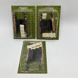 Pode incluir: Três pacotes de dobradiças pretas e cobre. Cada pacote contém duas dobradiças e é etiquetado com "colonnade".