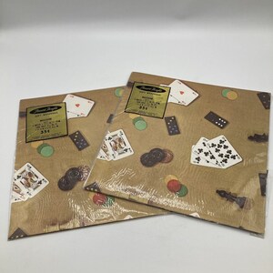 Peut inclure: Deux paquets de papier cadeau avec un fond beige et un motif de cartes à jouer, de jetons de poker et de dominos. Les paquets portent des étiquettes indiquant "Pleasant Thoughts Gift Wrapping".