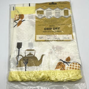 May include: A vintage kitchen valance in a sealed plastic bag. The valance features a white background with gold-colored kitchen utensils and fruit illustrations. The valance is 70 inches long and 12 inches wide, with a yellow ruffled trim.