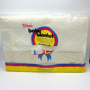 Pu&ograve; includere: Una coperta per bambini confezionata con il marchio "Triboro". La confezione presenta un logo circolare con le parole "baby blanket" e testo. La coperta &egrave; in un sacchetto di plastica trasparente. Le dimensioni sono 91 x 114 cm.