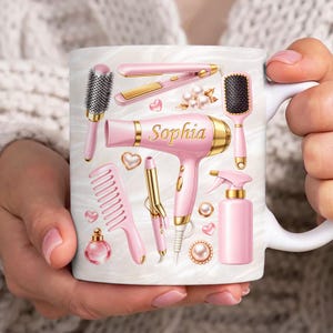 Puede incluir: Una taza de cerámica blanca con un asa negra y el texto "But First, Coffee" en un estilo manuscrito. La taza está sobre una superficie blanca. La taza mide 10 cm de alto.