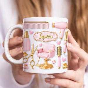 Puede incluir: Taza de cerámica blanca con herramientas de peluquería rosas y doradas y una silla de salón rosa. La taza tiene el nombre "Sophia" en letras doradas. Incluye un secador de pelo, un peine, unas tijeras y un rizador.