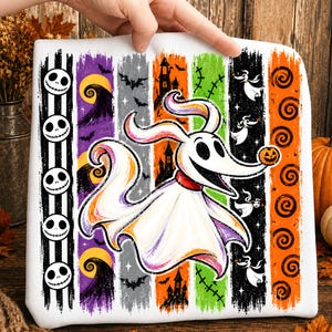 Pode incluir: Uma camisola branca com um gráfico central de um cão fantasma com uma pequena abóbora no nariz. O fundo consiste em riscas verticais em preto, roxo, cinzento, laranja e verde, decoradas com caveiras, morcegos e casas assombradas.