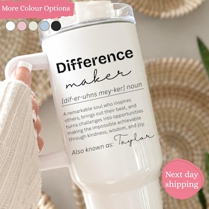 May include: A white stainless steel tumbler with a handle and a clear lid. The tumbler features black text that reads Difference maker, followed by a phonetic pronunciation, a definition of the term, and the custom name Taylor at the bottom.